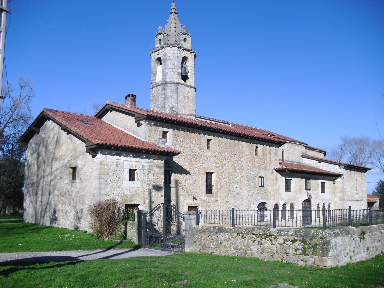 Fachada del Santuario de Nuestra Señora de Latas en Loredo, día soleado, entorno rural cántabro