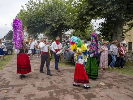 Romería popular con mesas al aire libre junto a una ermita, ambiente festivo de mediodía