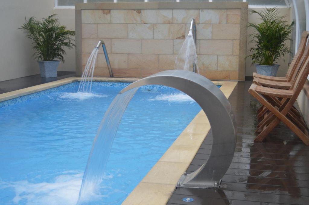 Piscina termal exterior del Balneario de Alceda entre montanas verdes del Valle de Toranzo, primeras horas de la manana