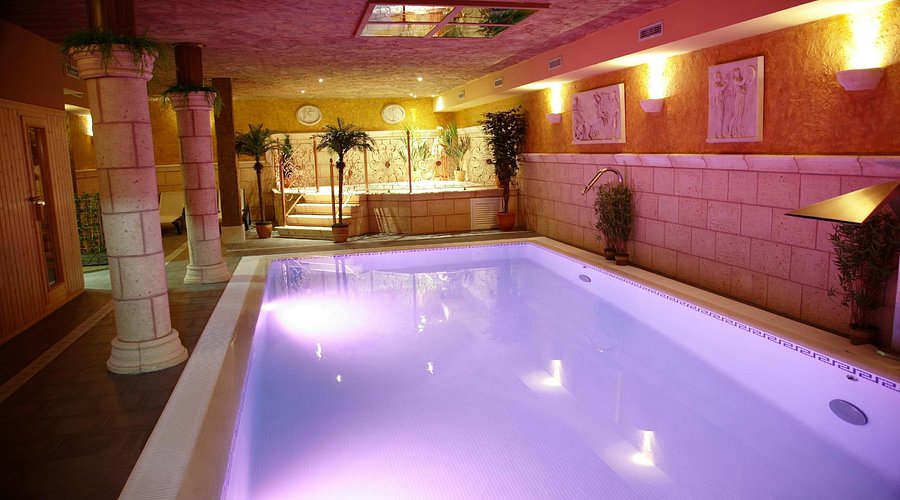 Piscina climatizada interior con jacuzzi de la Posada-Spa Privilegio de Vara en Noja, ambiente intimo y luz artificial calida