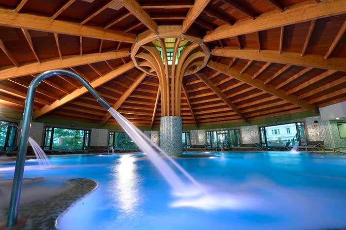 Piscina termal circular bajo una cupula de estilo romano en el circuito Balnea Romana de Castilla Termal Solares