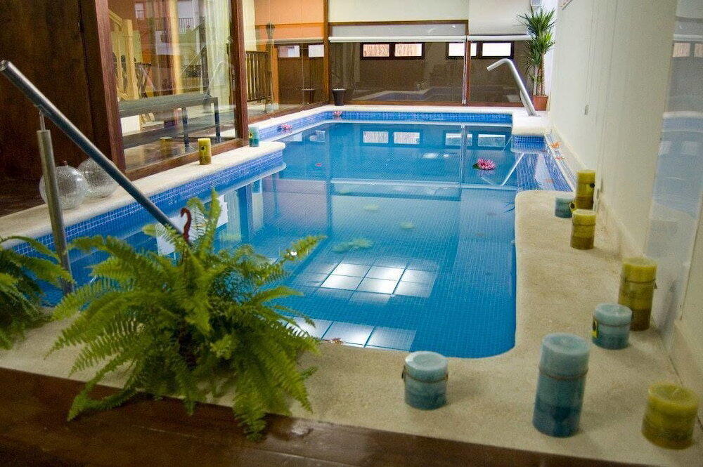 Piscina de spa con estructura de madera de bioconstruccion del hotel Agua Viva en Mino, Castro Urdiales, luz natural de dia nublado