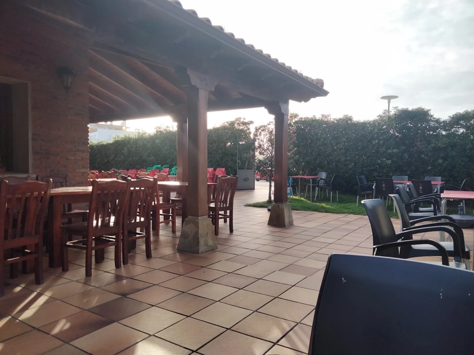Terraza y jardín del Restaurante Pescador en Bareyo con mesas al aire libre, ambiente diurno de verano.