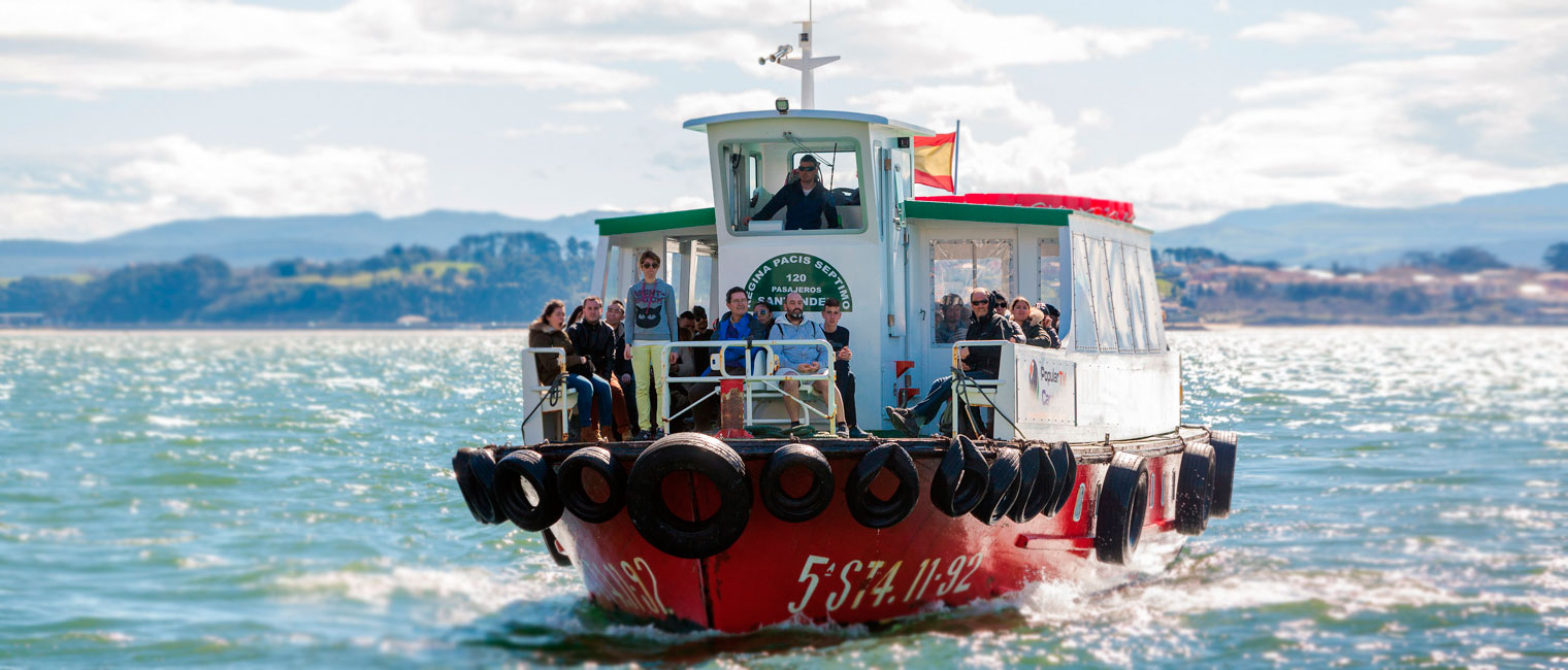Barco de pasajeros cruzando la bahía de Santander hacia Somo, con la ciudad de Santander al fondo