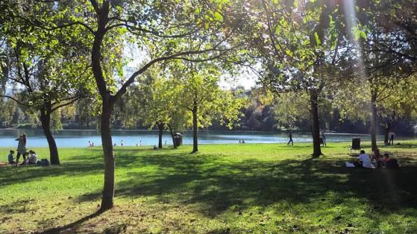 Zona de picnic con mesas de madera junto al agua en el Lago del Acebo, cerca de Cabárceno