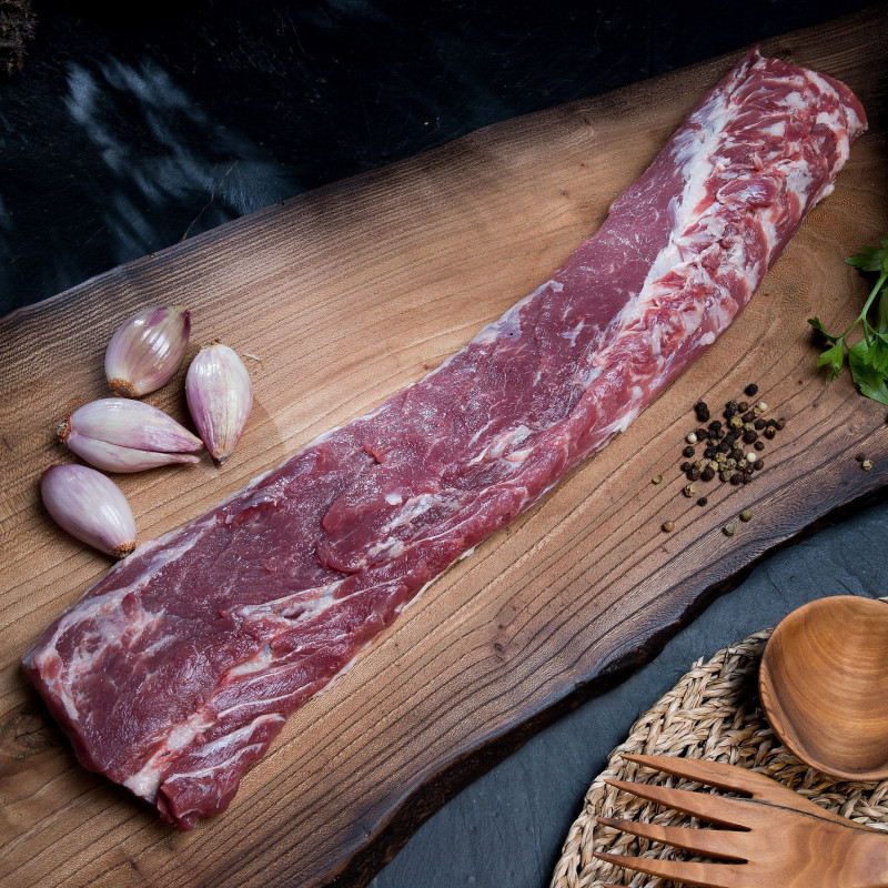 Mostrador de carnicería rural cántabra con piezas de carne de caza etiquetadas por temporada