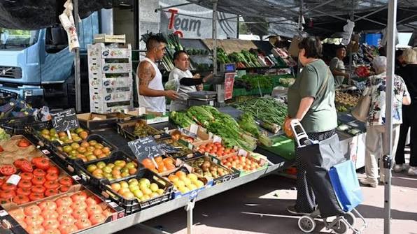 Mercadillo semanal al aire libre junto a la iglesia de Ajo, puestos de fruta, verdura y productos locales