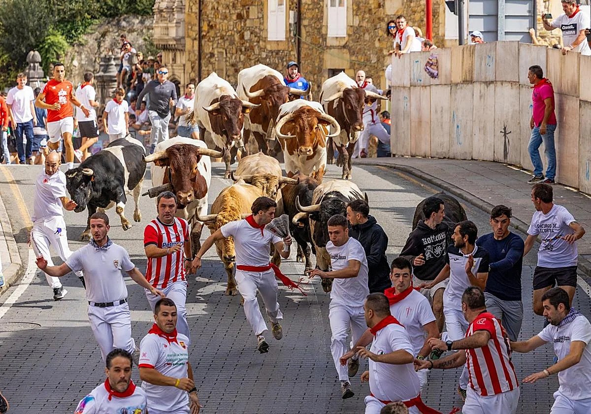 Calle principal de Ampuero, Cantabria, con el vallado de madera del encierro instalado y ambiente de gente esperando antes del mediodía.