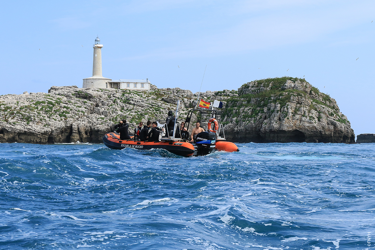 Vista de la costa rocosa cerca de la Isla de Mouro o la Costa Quebrada en un día soleado de verano, ilustrando el buceo en el Cantábrico