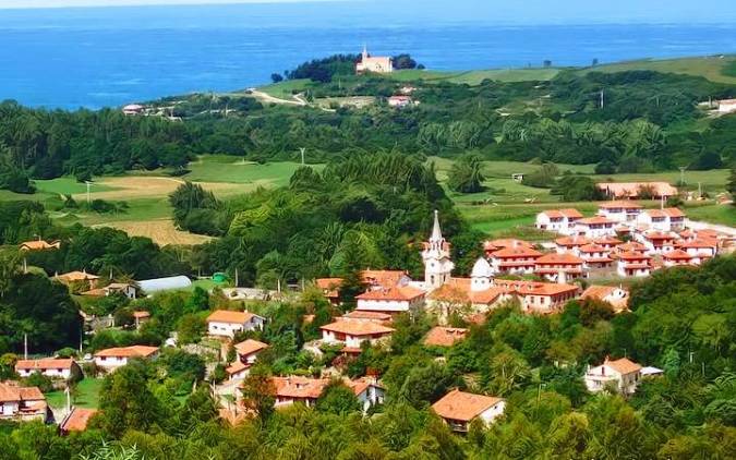 Torre indiana de piedra entre casas tradicionales en el núcleo del pueblo de Ruiloba