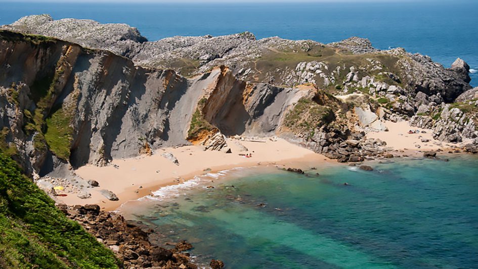 Familia haciendo una ruta de senderismo por el interior verde de Cantabria en un día templado de verano