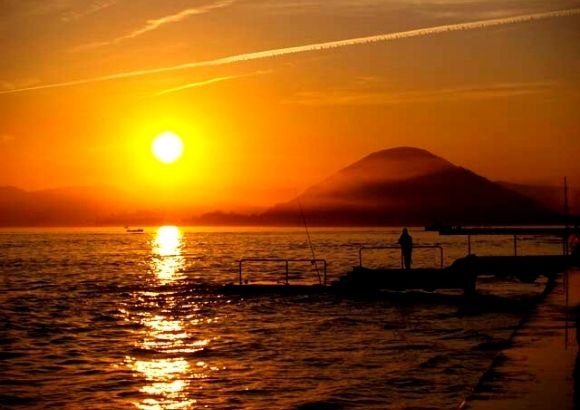 Playa de Cantabria casi vacía a finales de agosto, luz suave de atardecer y pocas sombrillas