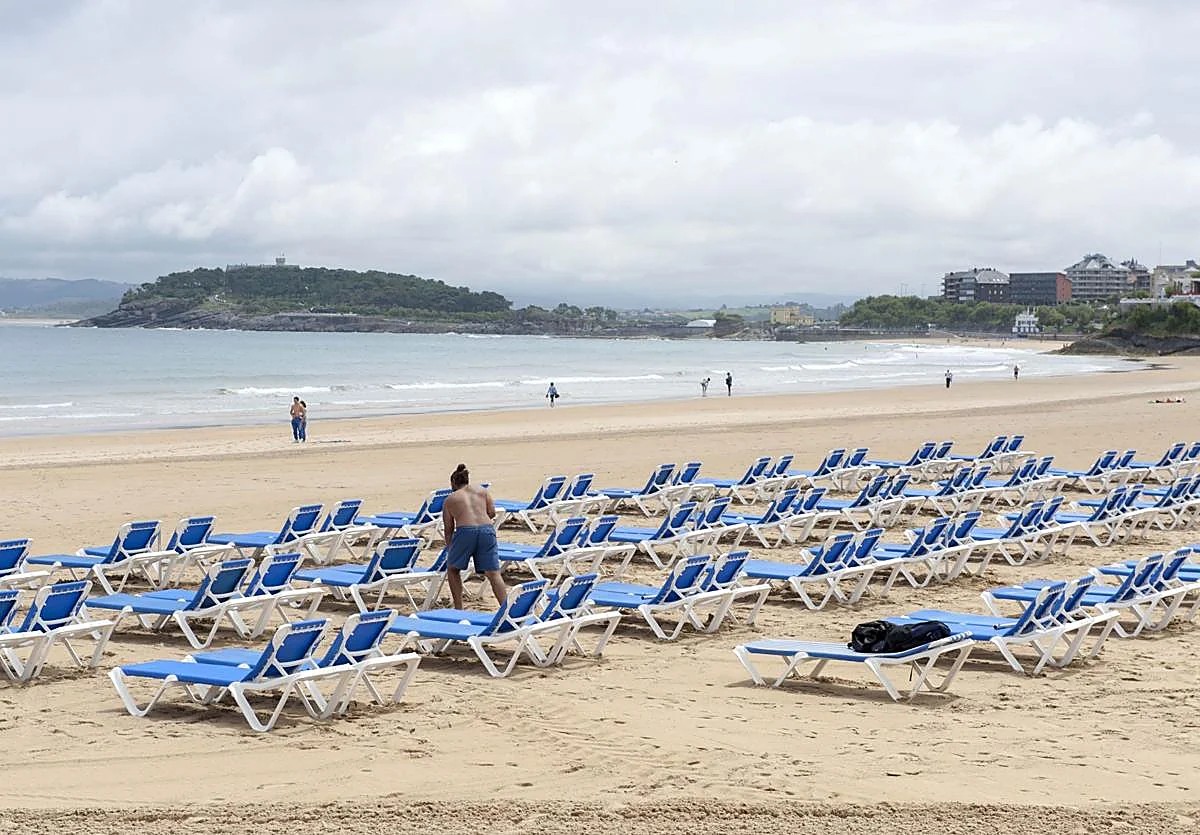 Vista general de una playa de Noja con sombrillas y hamacas de alquiler colocadas en temporada alta