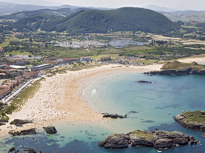 Playa de Ris en Noja, con el paseo marítimo y el quiosco de alquiler de hamacas al fondo