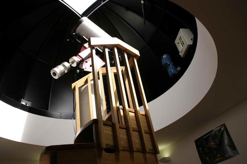 Interior de la cúpula del observatorio con el telescopio principal apuntando al cielo nocturno